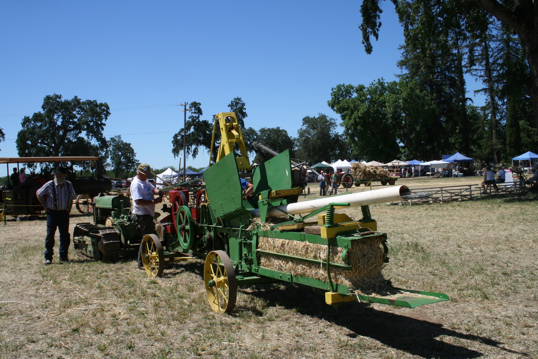 Volunteers running a restored hay press at a living history day on the Patrick Ranch.